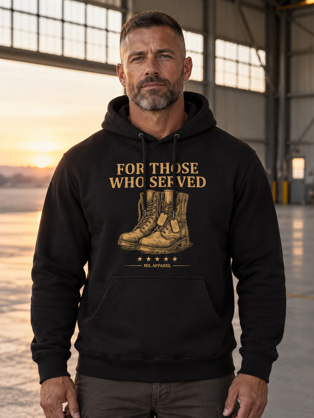 Veteran wearing the black Last Full Measure memorial hoodie in an aircraft hangar at dawn